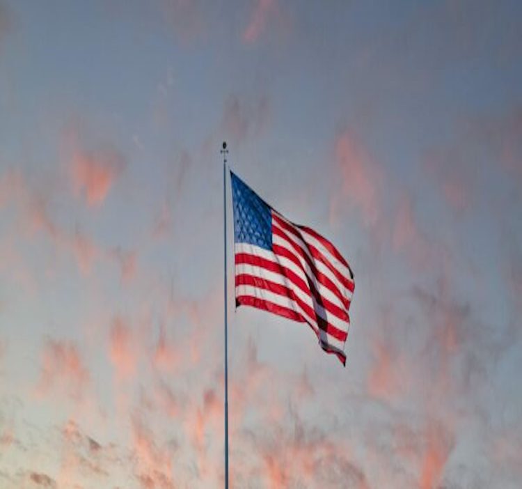 American flag flying at sunset against a cloudy sky — Jaxon's federal and defense vertical